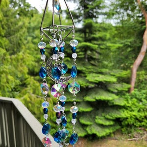 Mystic blue glass and ab crystal window hanging suncatcher.  Sparkles in sunlight, casts colorful rainbows.  11" long. Moon and star charm.
